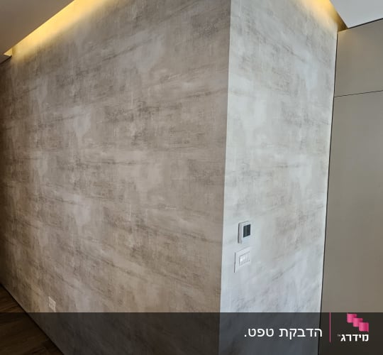 קיר עם טפט אפור ותאורה נסתרת